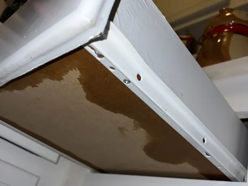 Water damage stain on the underside of a wooden drawer bottom.